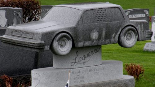 A unique gravestone shaped like a car, featuring the name "Laguerrero" and dates of birth and death.