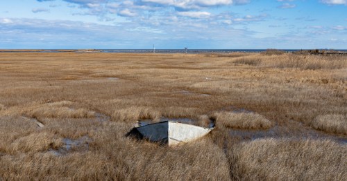 An abandoned boat half in the marsh in Slaughter Beach, Delaware.