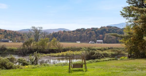 A standing swing overlooks the river at the whimsical cabin Airbnb rental in Johnson, Vermont.