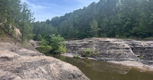 A narrow canal cuts through some large rocks at a small-town state park in Arkansas.