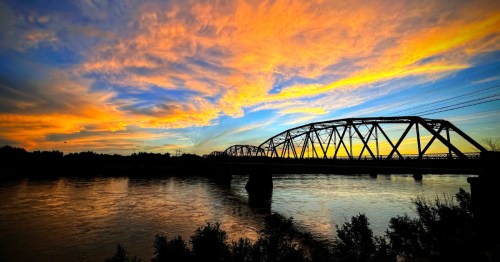 A fiery sunset over the Yellowstone River and the Yellowstone River Bridge in Glendive, Montana.
