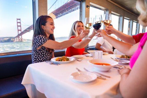 Women at table toasting on a City Cruises dining experience in San Francisco