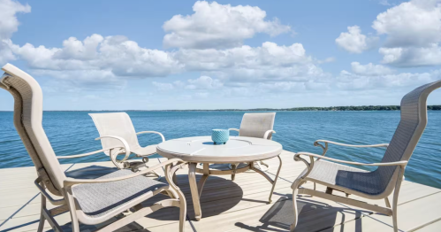 Patio seating on a private dock with views of the turquoise waters of Green Lake in Spicer, Minnesota.
