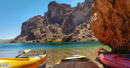 Colorful kayaks underneath a cove near the base of the Hoover Dam along a kayaking trail in Nevada.