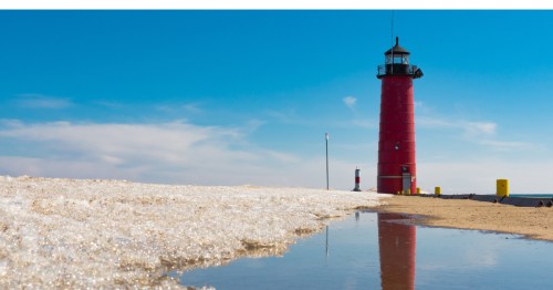 A red lighthouse on the beach in the daytime in Kenosha, Wisconsin.