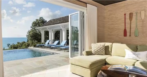 Modern Michigan pool house lounge with folding glass doors and coastal decor.