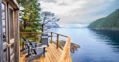 exterior and deck of a cabin at orca island cabins in seward alaska overlooking the water on an overcast day