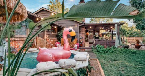 A refreshing plunge pool and tropical patio decor outside of a unique Kansas Airbnb.