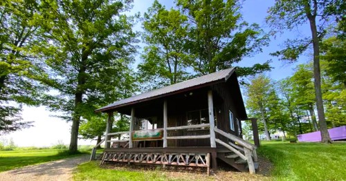Views of a cabin surrounded by trees at the Heron Farm, a secluded campground near Niagara Falls