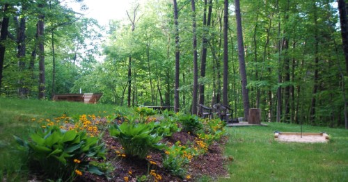 Beautiful secluded campsite near Shenandoah National Park in VA with wildflowers, a private horseshoe pit, green trees, and a level campsite.