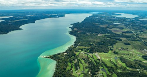 Wide aerial shot showing the sandbars and turquoise water of Torch Lake along Michigan's Chain of Lakes Water Trail.