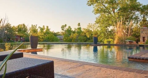 an infinity pool looks out over a lake in warr acres oklahoma