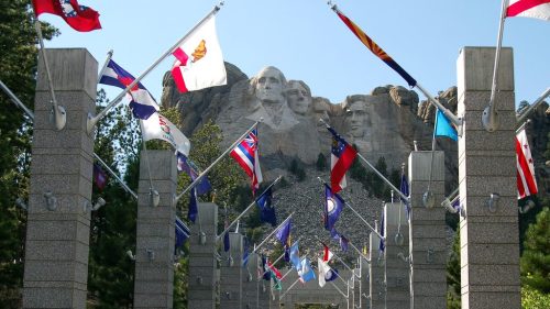 View of Mount Rushmore with flags lining a pathway in the foreground, showcasing the iconic presidential sculptures.