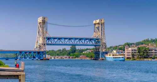 A scenic river town with a big blue bridge, and green bluffs in Houghton, a Michigan town like Patagonia