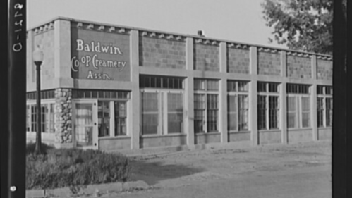 Historic building of Baldwin Co-op Creamery Association, featuring large windows and a stone facade.