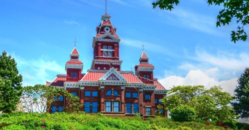 The grand architecture and red paint of the Whatcom building is seen on a hill in Bellingham, Washington.