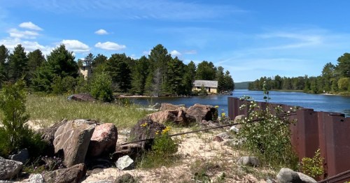 Beautiful shoreline view of the historic yellow Mendota Lighthouse across the water in Bete Grise, Michigan.