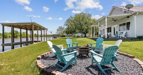 exterior of an airbnb with a covered dock on the bayou and a fire pit with seating overlooking the water in Erath, Louisiana