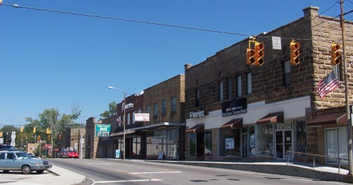 Main street in downtown Jamestown, Tennessee, with historic buildings and shops under a bright blue sky.