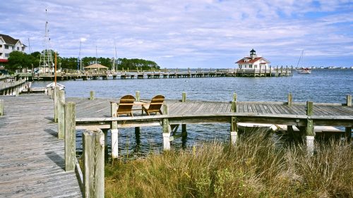 Harbor view of Manteo, NC, showing the sound, a dock, and a big blue sky overhead.
