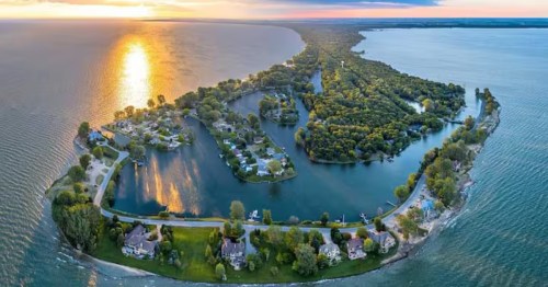 Aerial sunset view of a luxury peninsula lakefront vacation home in Pigeon, MI.