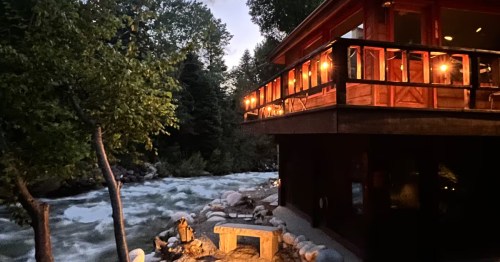 exterior of a cabin with a deck directly over a rushing river in Sandy, Utah