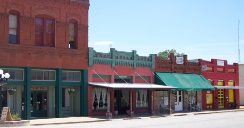 Colorful historic storefronts in Smithville, Texas, showcasing vintage brick architecture, awnings, boutiques, and locally owned businesses along the downtown streetscape.