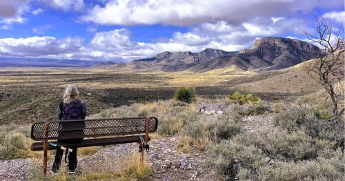 A woman sitting on a bench overlooking the mountains in Benson, a small town near Kartchner Caverns in AZ.