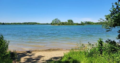 Views of Summit Lake in Indiana, featuring pretty blue waters framed by greenery.