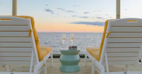 An oceanfront vacation rental in Mississippi with two chairs and champagne.