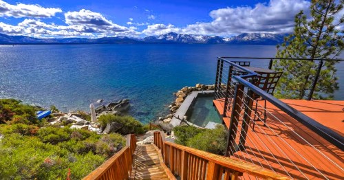 Steps leading to Lake Tahoe at a waterfront Airbnb in Nevada, with snow-capped mountains in the background.