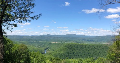 Overlook from Watoga State Park with mountains in the distance and a blue sky overhead.