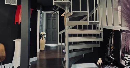 A central staircase area with kooky decor and theming at the Wednesday's Lair Airbnb in Lincoln, Illinois.