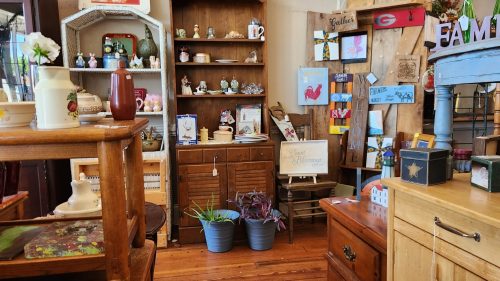 A cozy antique shop filled with various vintage items, shelves, and decorative pieces in warm wooden tones.