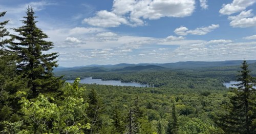 An overhead view of Bald Mountain in New York, with trees and a lake in the background.