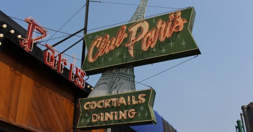 An exterior neon sign during the day for Club Paris in Alaska.
