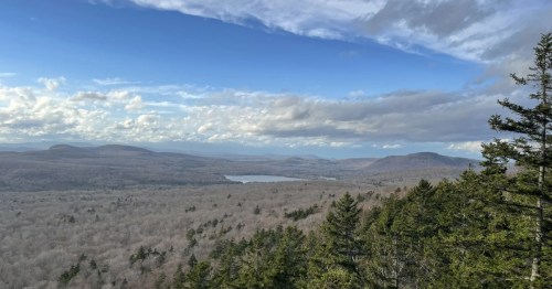 An overlook from Devil's Hill in Vermont, looking out on a wide vista of plains and mountains.