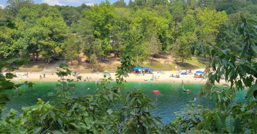 Tree branches frame a view of a hidden beach in Kentucky.