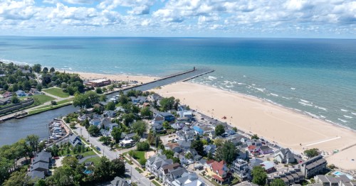 A picturesque small town with a wide, white beach, blue water, and a pier. It's South Haven, one of the best day trips from Grand Rapids.