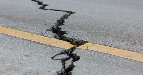 A massive crack in the asphalt after an earthquake.