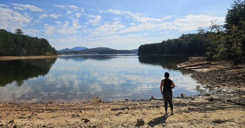 A woman stands on the banks of Lake Nottely, an underrated lake in Georgia.
