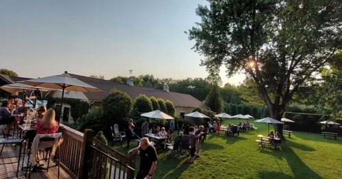 Chairs and tables filled with people sit on the patio and lawn at the White Horse Winery in Hammonton, New Jersey.
