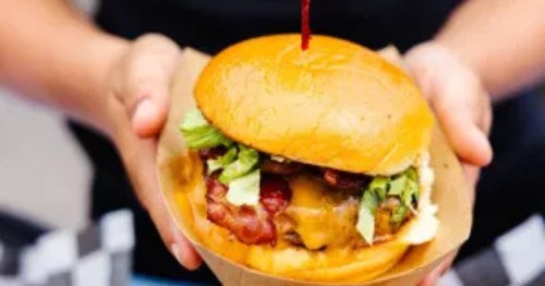 two hands hold a burger at al's burger shack in north carolina