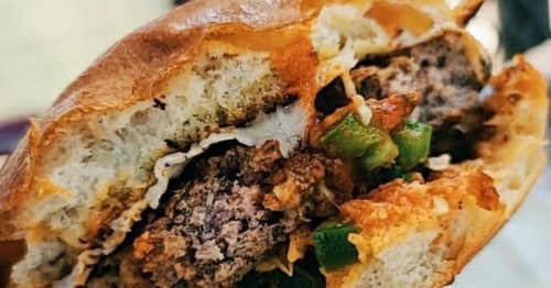 closeup of a smashburger with cheese, peppers, and other toppings at blazes burgers in maine