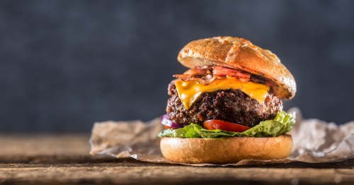 a large burger patty topped with cheese and bacon