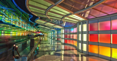 the colorful glass interior of a passenger tunnel inside a terminal at chicago o'hare international airport in illinois