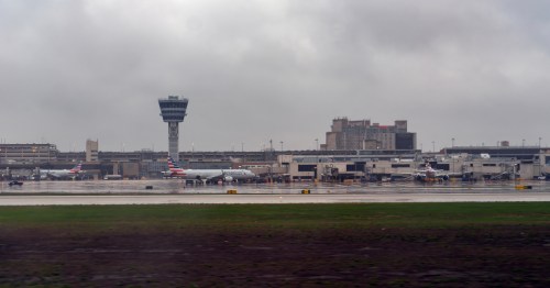 air traffic control tower and a plane on the runway at Philadelphia International Airport (PHL) in PA on a coudy day