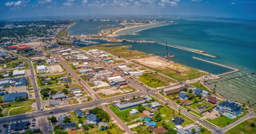 Aerial view of Rockport, Texas, highlighting the harbor, marina, waterfront neighborhoods, and the blue waters of the Texas Gulf Coast.