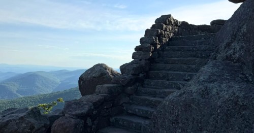 Stone stairs leading to the summit of Sharp Top Mountain in Virginia, surrounded by mountains.