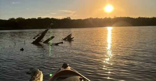 Golden hour sunset view from a kayak on the water at Lake Darling State Park in Iowa.